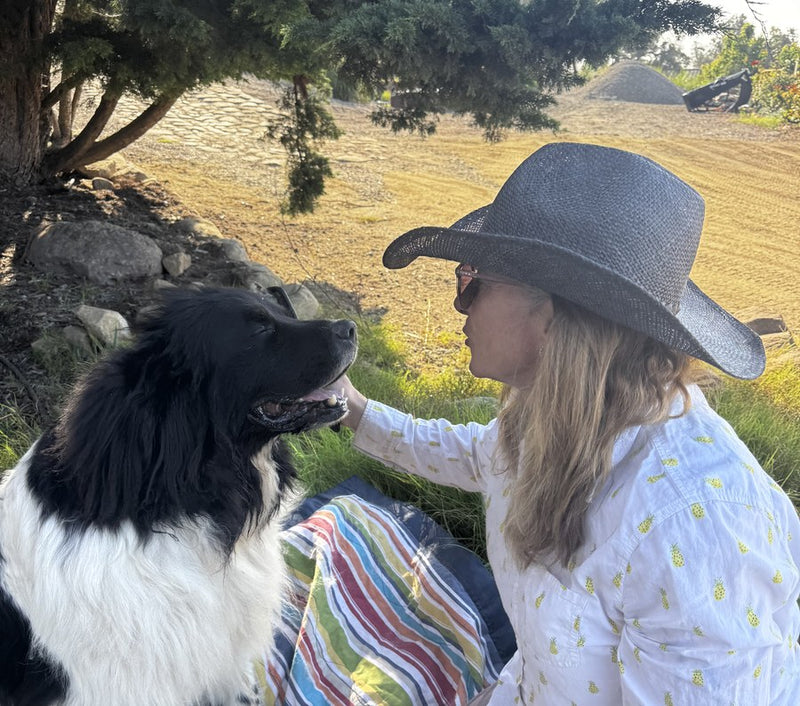 Margo and Cosmo the dog sitting under a tree on the farm